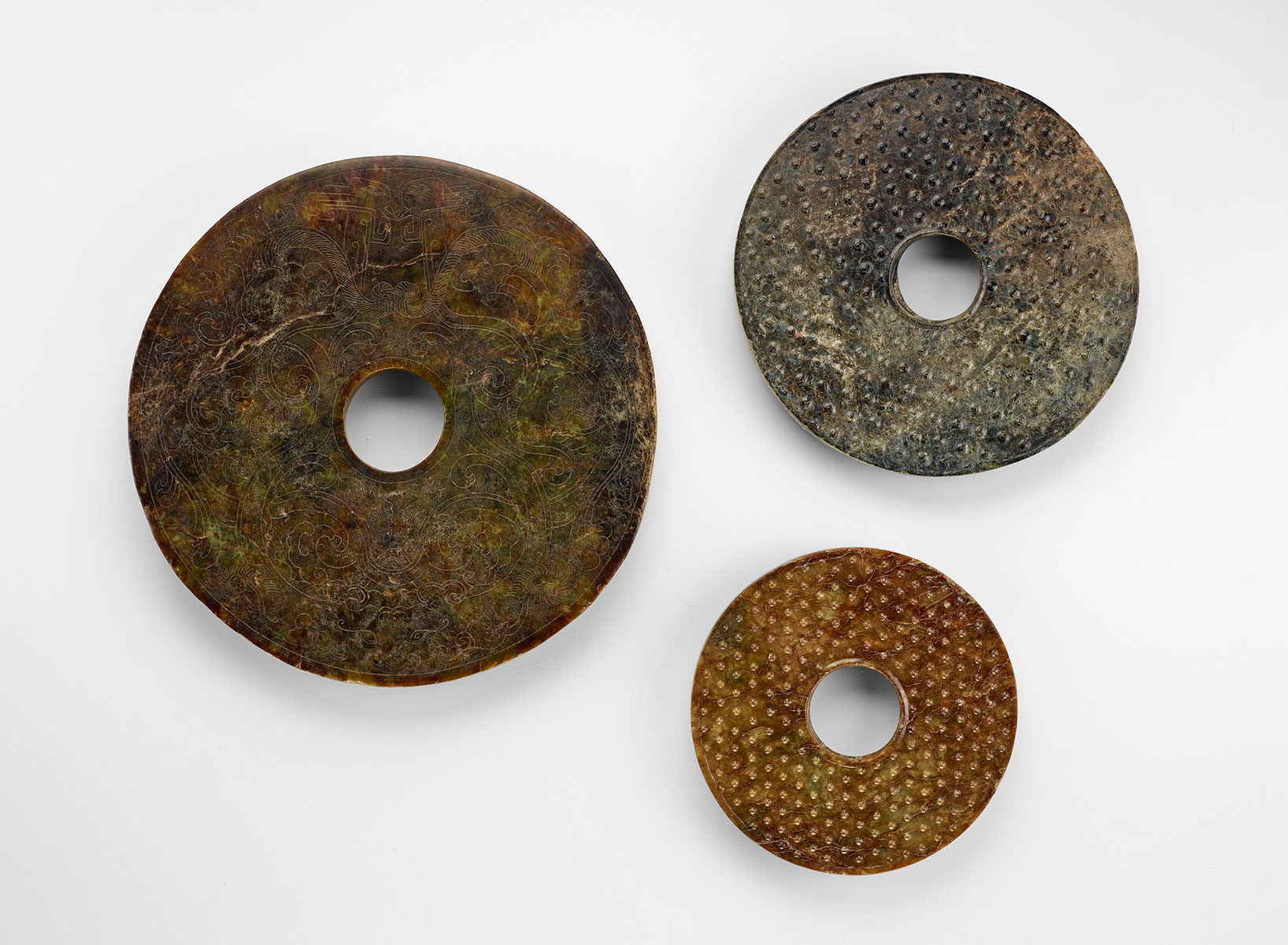 Fig. 11 Three nephrite disks from the Neolithic Liangzhu 良渚 culture (ca. 3300–ca. 2250 BCE) with later decoration added. 